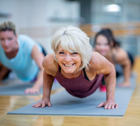 woman performing pushups on a gym mat